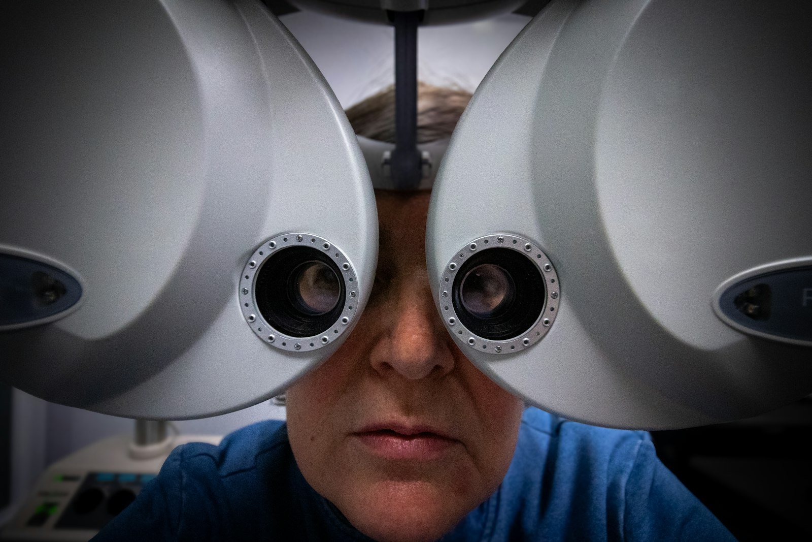 Patient derrière un réfracteur pendant un examen de la vue